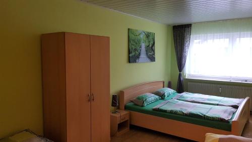 een kleine slaapkamer met een bed en een raam bij Ferienwohnung Ziegler in Steinau an der Straße