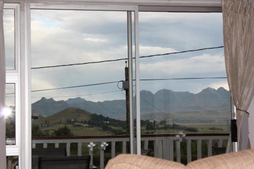 a room with a large window with a view of mountains at Knock Out View Clarens in Clarens