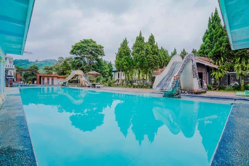 a pool at a resort with a water slide at RedDoorz Plus near Tapal Kuda Cugenang Cianjur in Cianjur