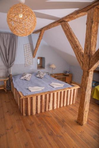 een slaapkamer met een houten bed in een kamer bij Placówka - całoroczny dom wakacyjny in Wydminy