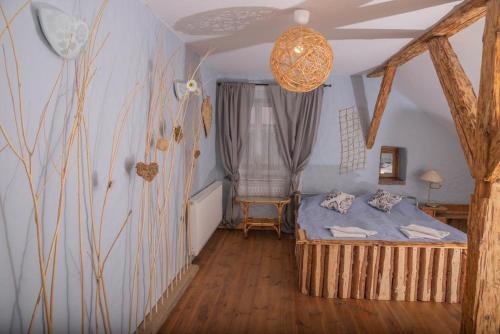 a bedroom with a bed and a chandelier at Placówka - całoroczny dom wakacyjny in Wydminy