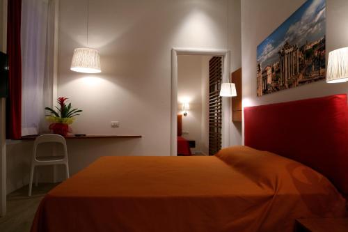 um quarto com uma cama com lençóis e luzes laranja em Why Not Roma Suite em Roma