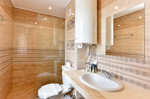 a bathroom with a sink and a toilet at Sirena Palace Family Hotel in Obzor