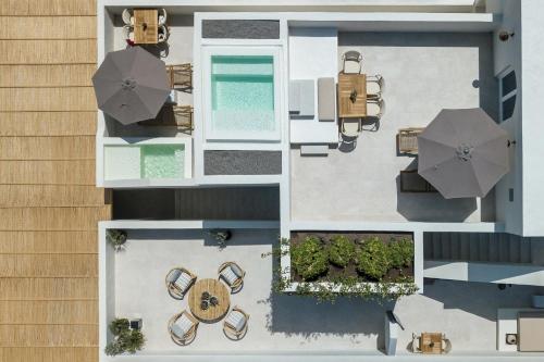 an overhead view of a house with a pool and umbrella at Istoria, a Member of Design Hotels in Perivolos