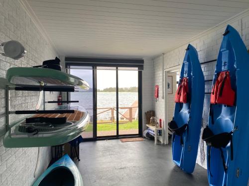 a room with two blue surfboards in a room with a window at Serenity by the Lake - Romantic Waterfront Couple's Getaway in Marks Point