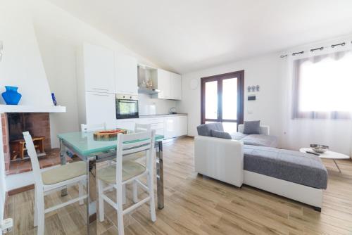 a kitchen and living room with a table and a couch at VILLA ALOE in Costa Paradiso