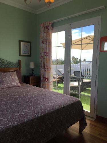 a bedroom with a bed and a sliding glass door at Villa Costa Golf in Costa Teguise