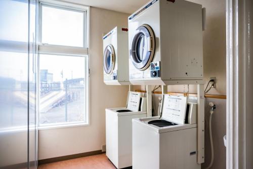 a room with two washing machines and a window at Tabist Hotel Daimu Minami-Souma in Minamisouma