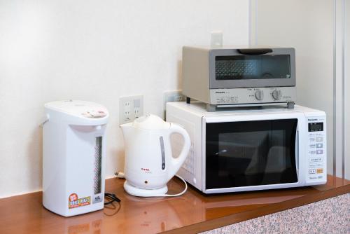 a microwave and a blender on a wooden table at Tabist Hotel Daimu Minami-Souma in Minamisouma
