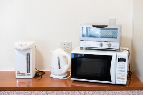 a microwave and a coffee maker on a table at Tabist Hotel Daimu Minami-Souma in Minamisouma