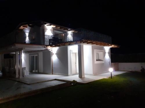 a white house lit up at night with a balcony at Imperial casa vacanze in Ladispoli