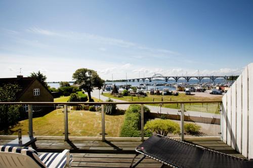 a balcony with a bench and a view of a bridge at Feriecentret Østersø Færgegård in Kalvehave