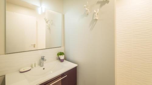 a bathroom with a sink and a mirror at Plein Sud avec Jacuzzi Privatif et parking privé in Sarlat-la-Canéda