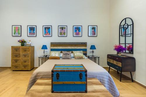 1 dormitorio con 1 cama, vestidor y cuadros en la pared en La Gatta Cenerentola Rooms en Nápoles
