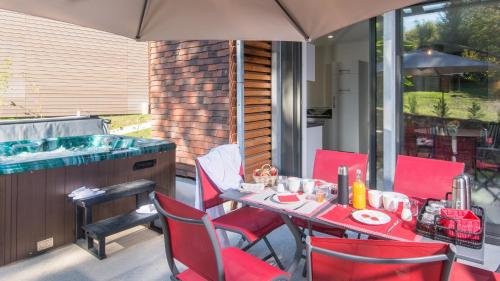 un patio avec une table et des chaises et un bain à remous dans l'établissement Plein Sud avec Jacuzzi Privatif et parking privé, à Sarlat-la-Canéda