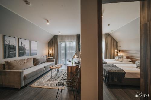 uma sala de estar com um sofá e uma cama num quarto em Lake Hill Karkonosze Apartments em Sosnówka