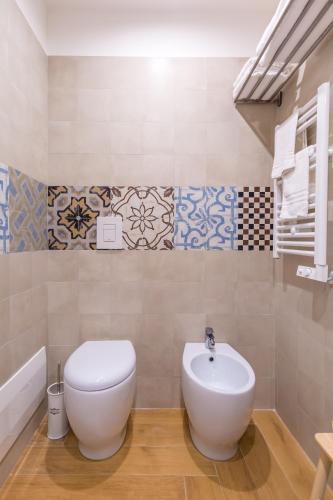 a bathroom with a toilet and a sink at La Gatta Cenerentola Rooms in Naples