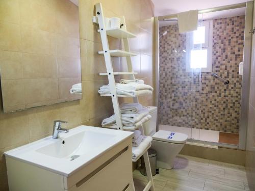 a bathroom with a sink and a toilet and a towel rack at Playa Romana Kione Rentals in Alcossebre