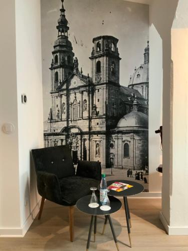 a living room with a wall mural of a church at Altstadthotel Arte in Fulda