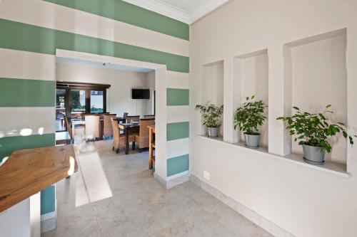 a hallway with green and white striped walls with potted plants at De Akker Guest House in Bloemfontein