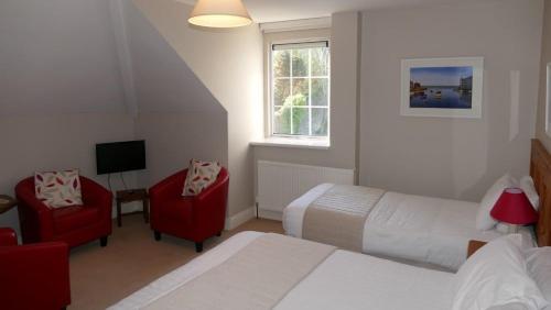 
a hotel room with two beds and a television at Avonmore House B&B in Youghal
