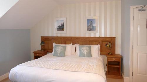 1 dormitorio con 1 cama blanca y 2 mesitas de noche en Avonmore House, en Youghal