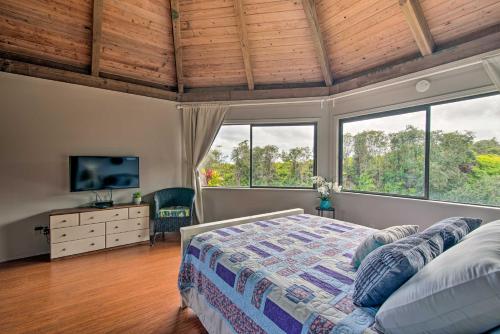a bedroom with a bed and a tv and windows at Hilo Couples Retreat about 6 Miles to Honolii Beach! in Hilo