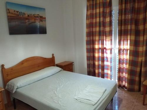 a bedroom with a bed and a window at Apartamento La Atalaya C-162 in Conil de la Frontera