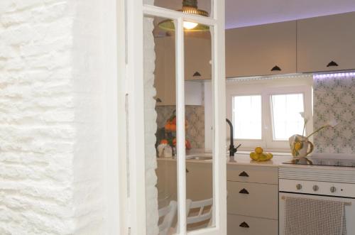 a kitchen with white cabinets and a counter top at LEÓN BLANCO pleno centro 6 personas CHIMENEA TERRAZA CON VISTAS in Carmona