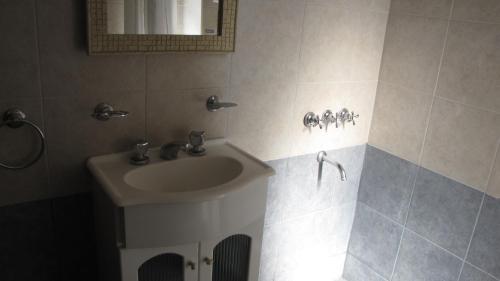 y baño con aseo y espejo. en el Departamento Villa Gesell Norte sobre Playa y 310 Vista al Mar en Villa Gesell
