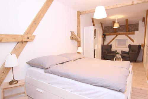 a bedroom with a white bed and a chair at Spindler Hof Harz 