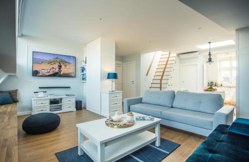 a living room with a blue couch and a table at Sky and Sea by Renters Prestige in Sopot