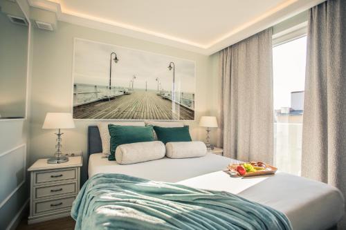 a bedroom with a bed with a painting of a pier at Sky and Sea by Renters Prestige in Sopot