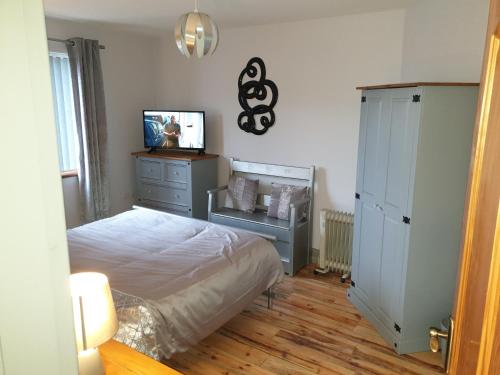 a bedroom with a bed and a tv and a dresser at CASTLE-VIEW in Castlerock