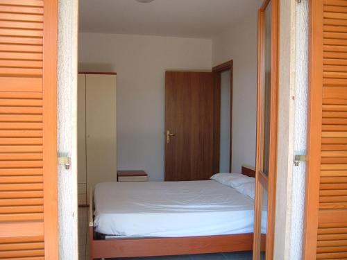 een slaapkamer met een bed en een houten deur bij Walhalla in Alba Adriatica