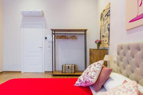 a bedroom with a red bed and a mirror at La Gatta Cenerentola Rooms in Naples