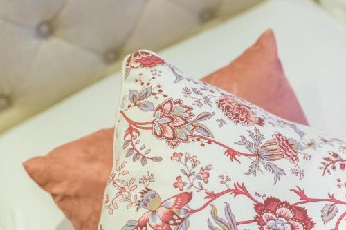 a pillow with a flower pattern on it at La Gatta Cenerentola Rooms in Naples