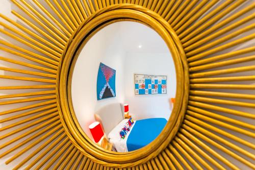 a mirror in a bedroom with a blue bed at La Gatta Cenerentola Rooms in Naples