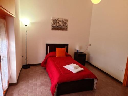 a bedroom with a red bed with a red blanket at Villa Terzaghi in Gorla Minore