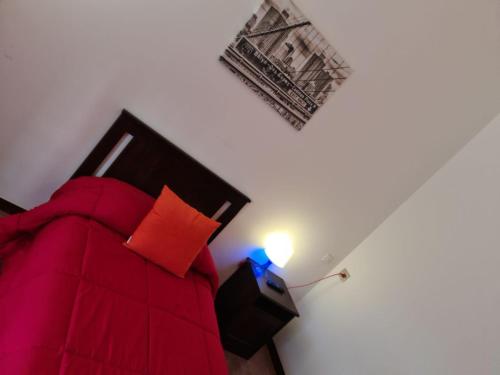 a bedroom with a red couch and a lamp at Villa Terzaghi in Gorla Minore