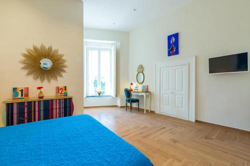 a bedroom with a blue bed and a desk at La Gatta Cenerentola Rooms in Naples