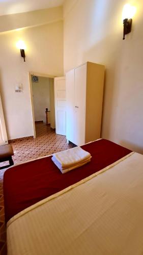a bedroom with a bed with a dresser in it at Ruby Apartments 4 in Calangute
