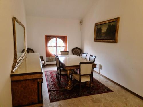 a dining room with a table and chairs and a mirror at Villa Terzaghi in Gorla Minore