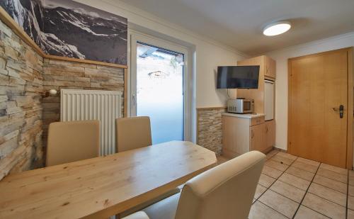 a kitchen and dining room with a wooden table and chairs at Ski & Bike Appartements Forsthaus in Saalbach Hinterglemm