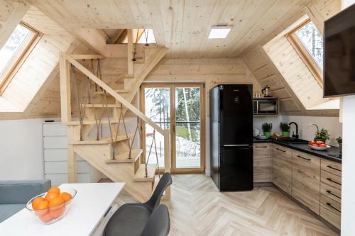 eine Küche in einem winzigen Haus mit einer Treppe in der Unterkunft TatryTop Apartamenty Alpejski SPA in Kościelisko