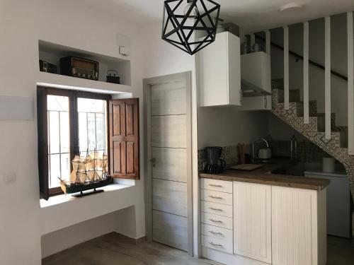 a kitchen with white cabinets and a window and stairs at Home SEA&DREAMS OldTown I in Calpe