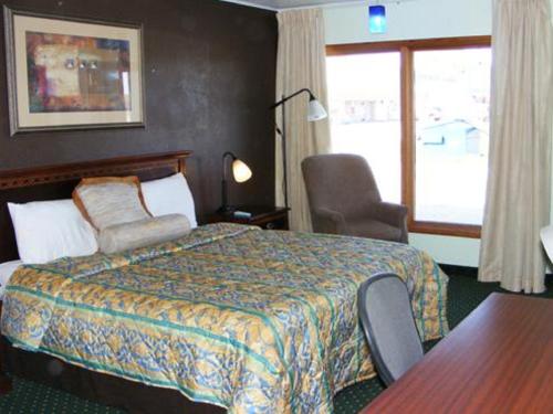 um quarto de hotel com uma cama e uma janela em Budget Inn Palmyra em Palmyra