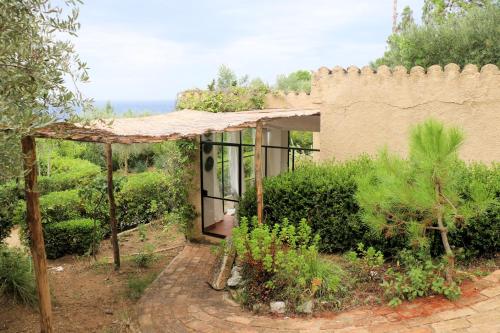 a house with a wall and a brick walkway at Case di Berto in Capo Vaticano