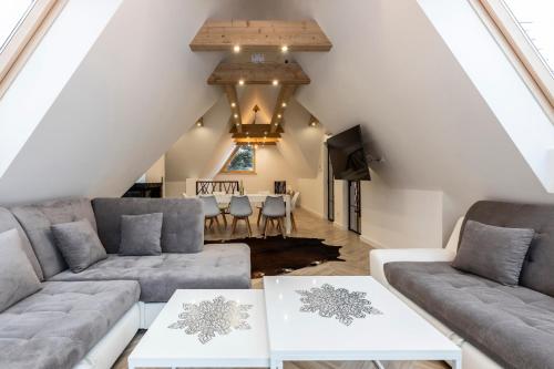 ein Wohnzimmer mit 2 Sofas und einem Tisch in der Unterkunft TatryTop Apartamenty Alpejski SPA in Kościelisko