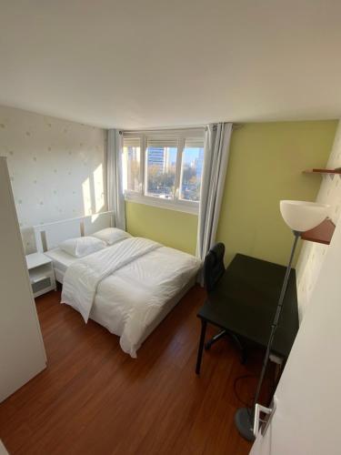 1 dormitorio con cama blanca y ventana en Chambre (Pluton) - Proche gare TGV et PARIS, en Massy